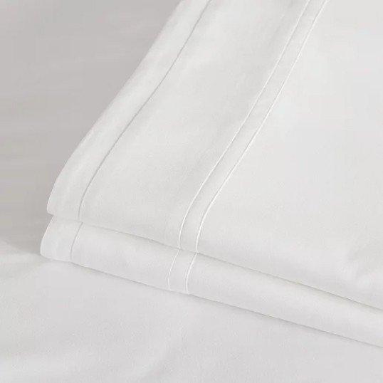 a close up of a white sheet on a bed