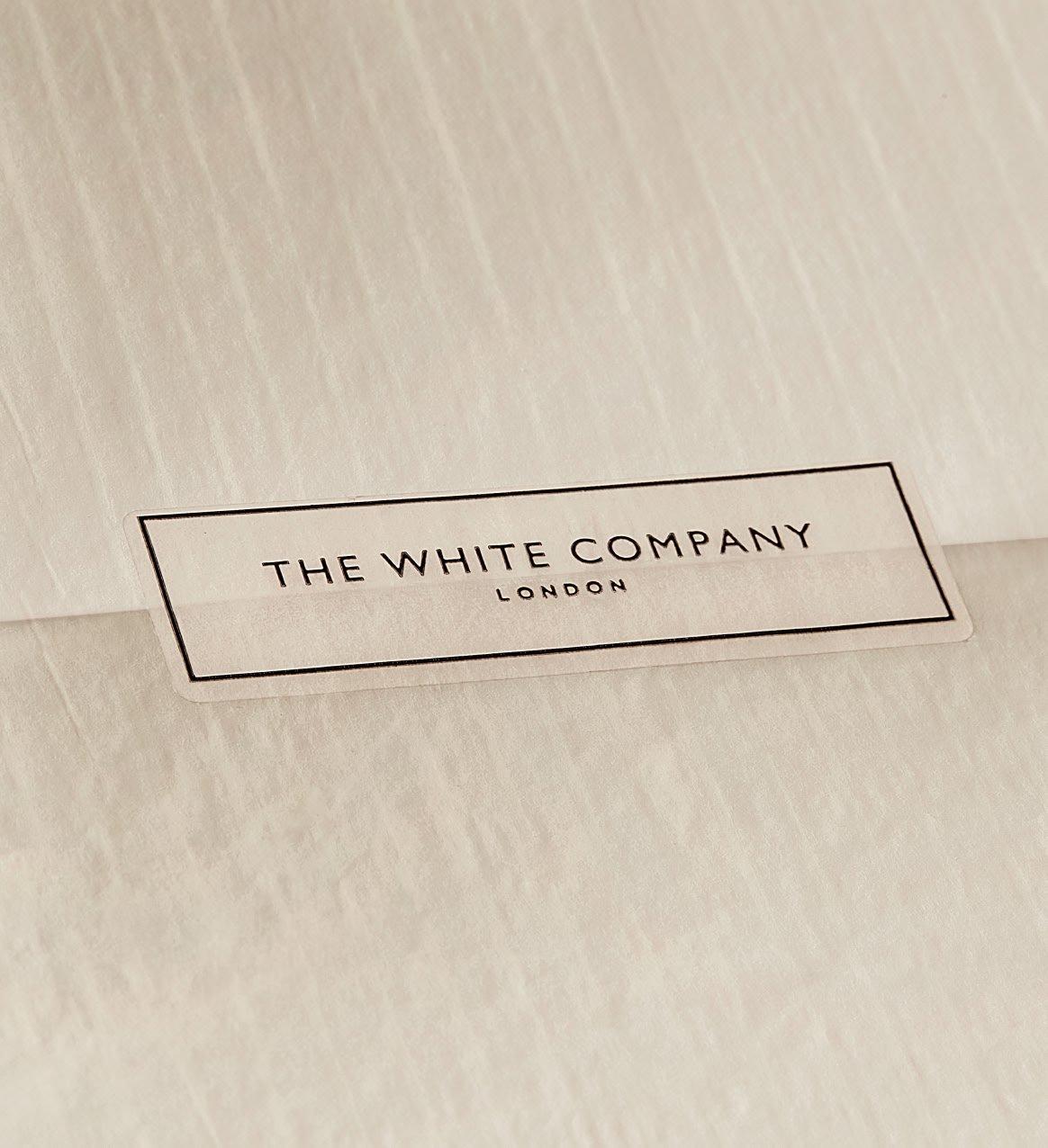 a black bow on a white box with a white ribbon