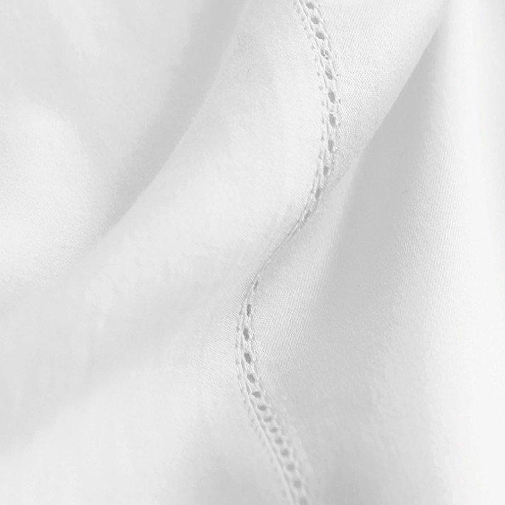 a close up of a white sheet with a small stitch