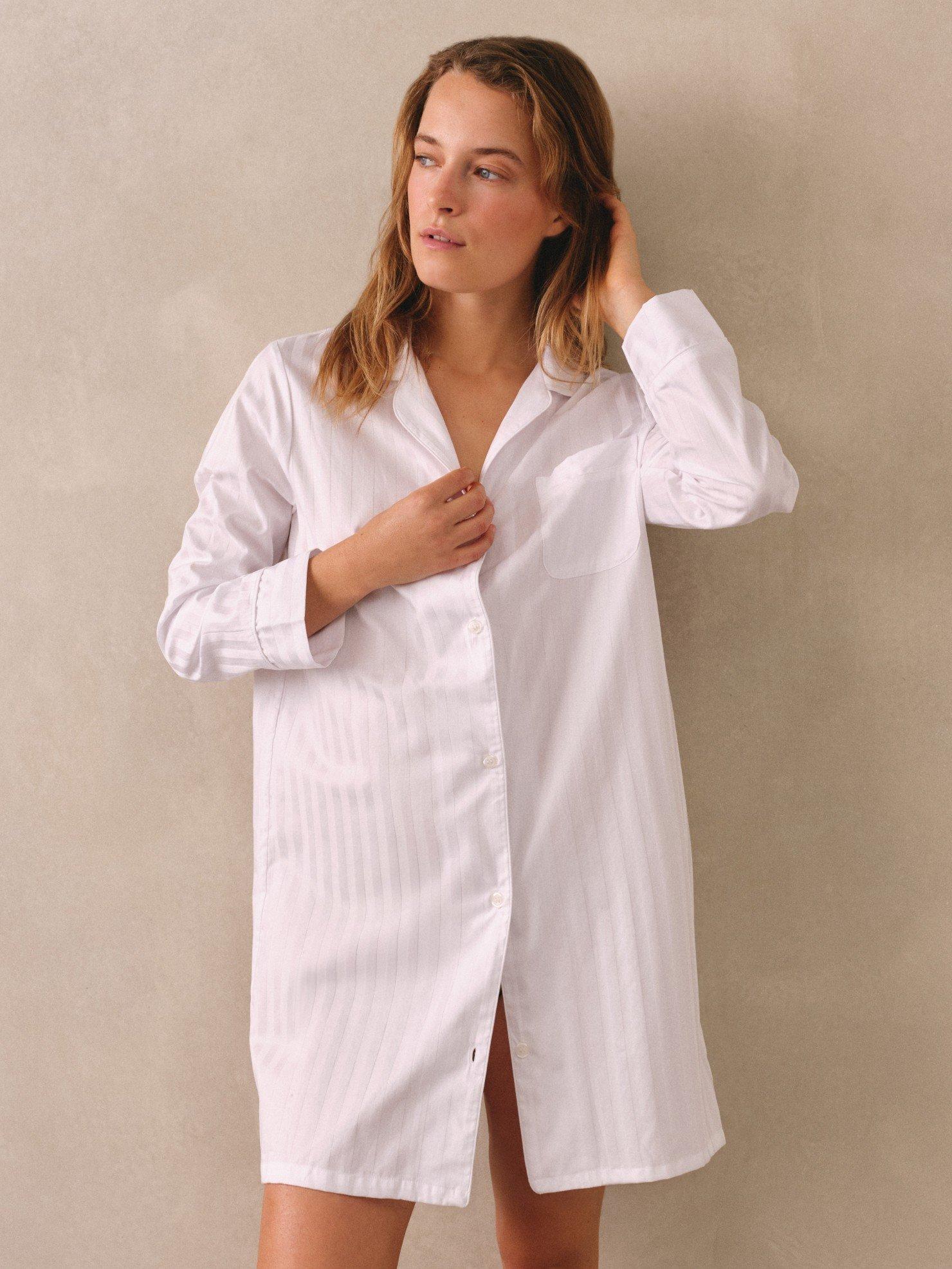 a woman in a white shirt and pajama pants standing