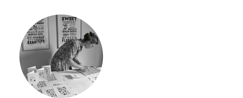 a woman at a table cutting out cards with a black and white photo