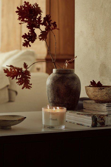 a table with a candle and a vase of flowers on it