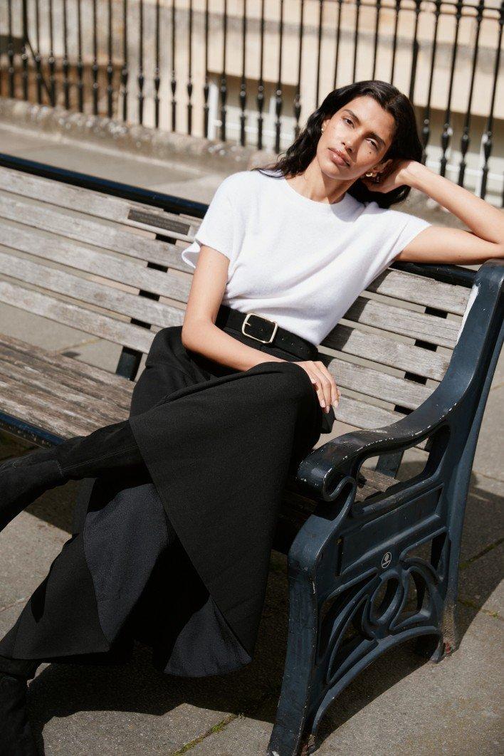 a woman sitting on a bench in a city street