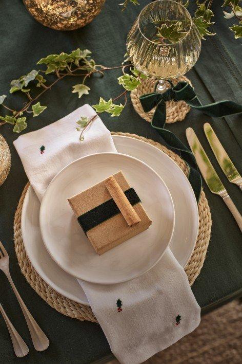 a white plate with a green napkin on it next to a green plate with a green nap