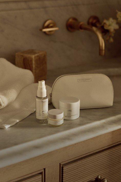 a bathroom counter with a white bag and a bottle of lotion