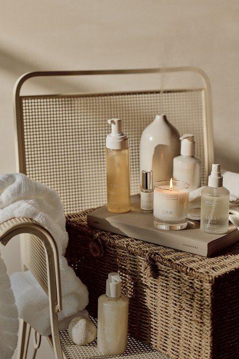 a bedside table with fragrances and candles on it