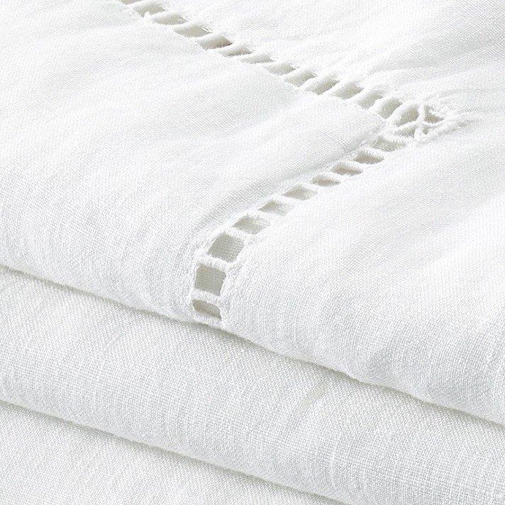 a stack of white sheets with holes in them