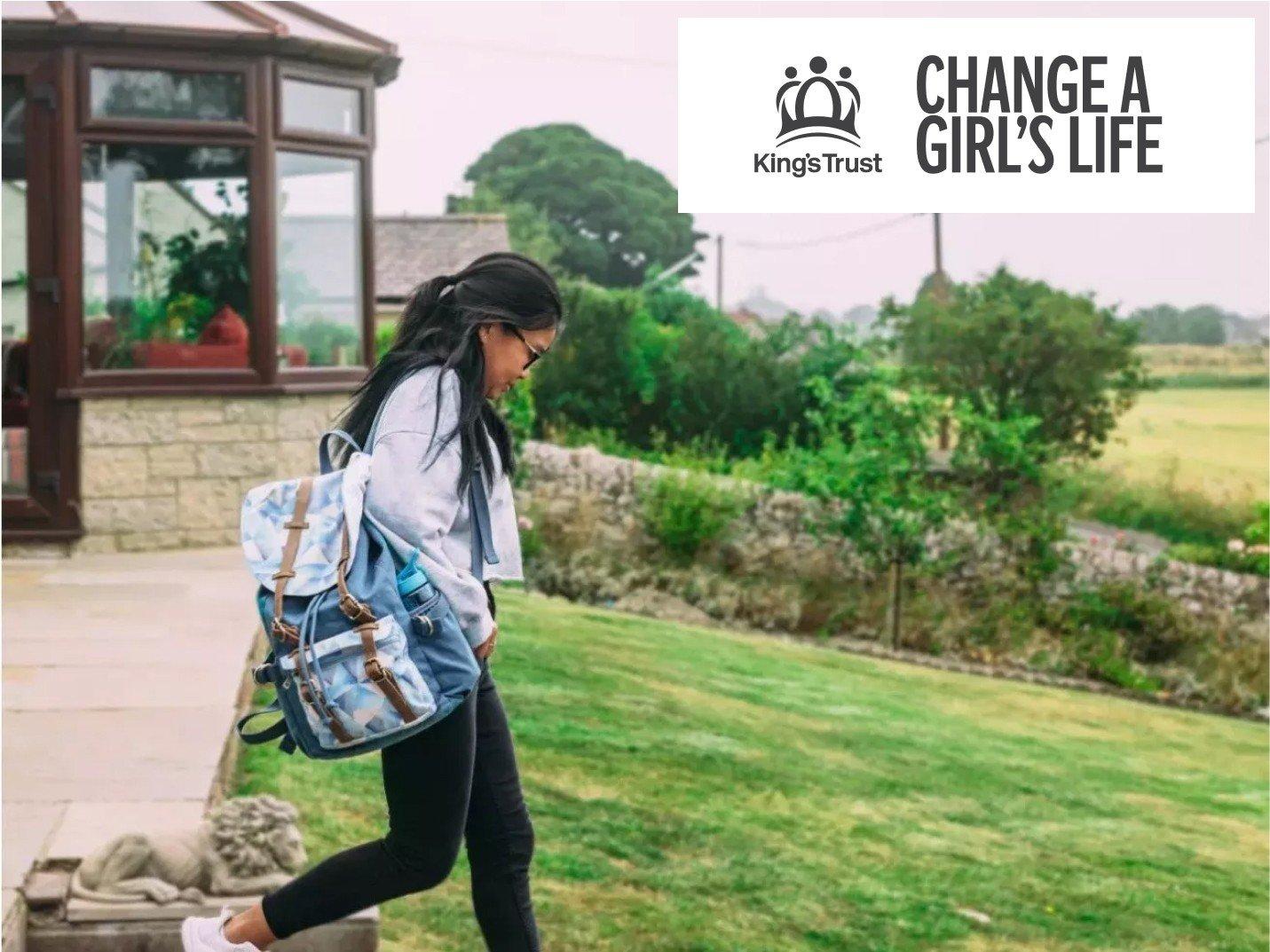 a woman walking down a path with a backpack