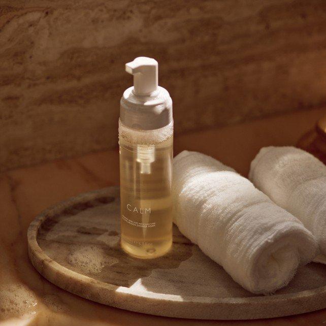 a wooden tray with two towels and a bottle of lotion