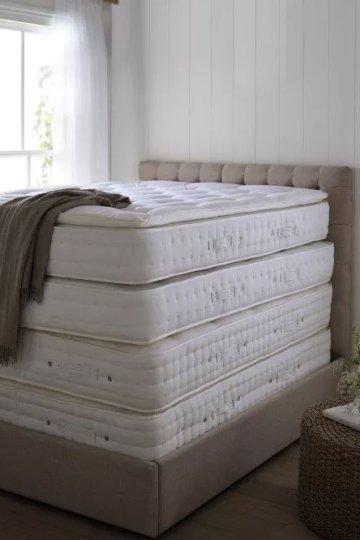 a stack of mattresses in a room with a window