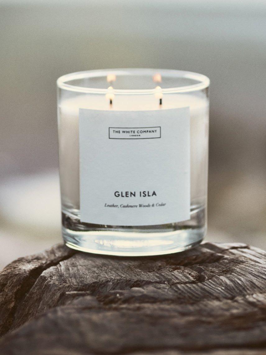 a candle sitting on top of a rock on a beach