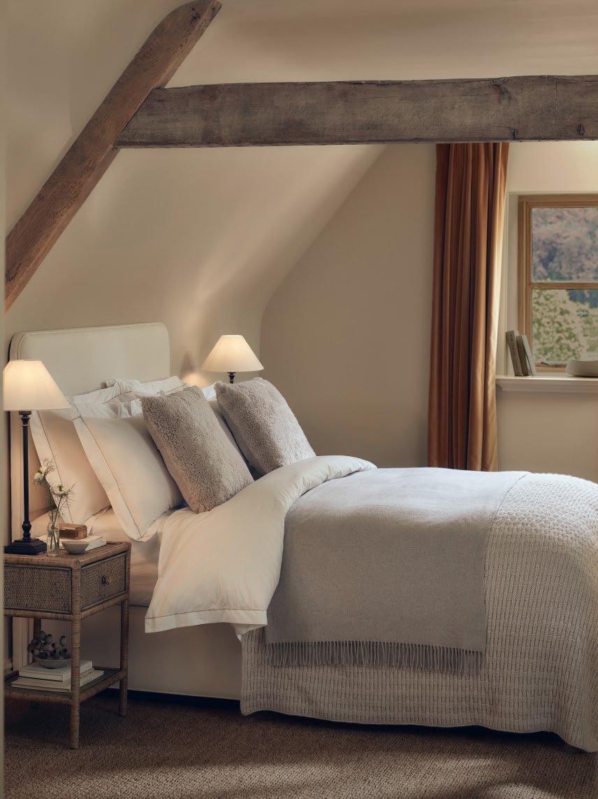 a bedroom with a bed, a nightstand, and a window
