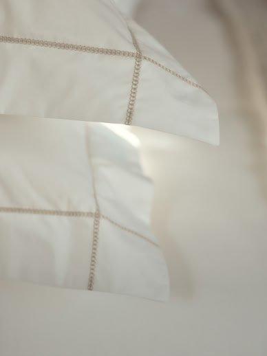 a close up of a white bed with a white sheet