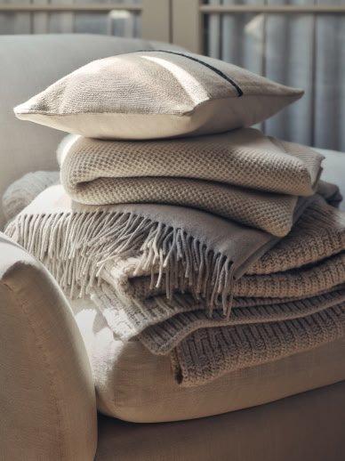 a stack of blankets piled on top of each other on a chair