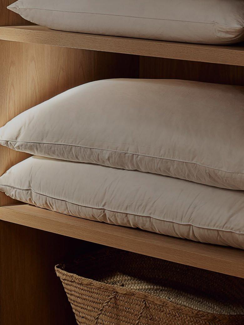 a shelf with two pillows on it in a wooden cabinet