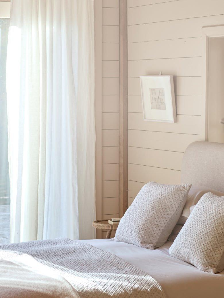 a bed with white sheets and pillows on a white bed