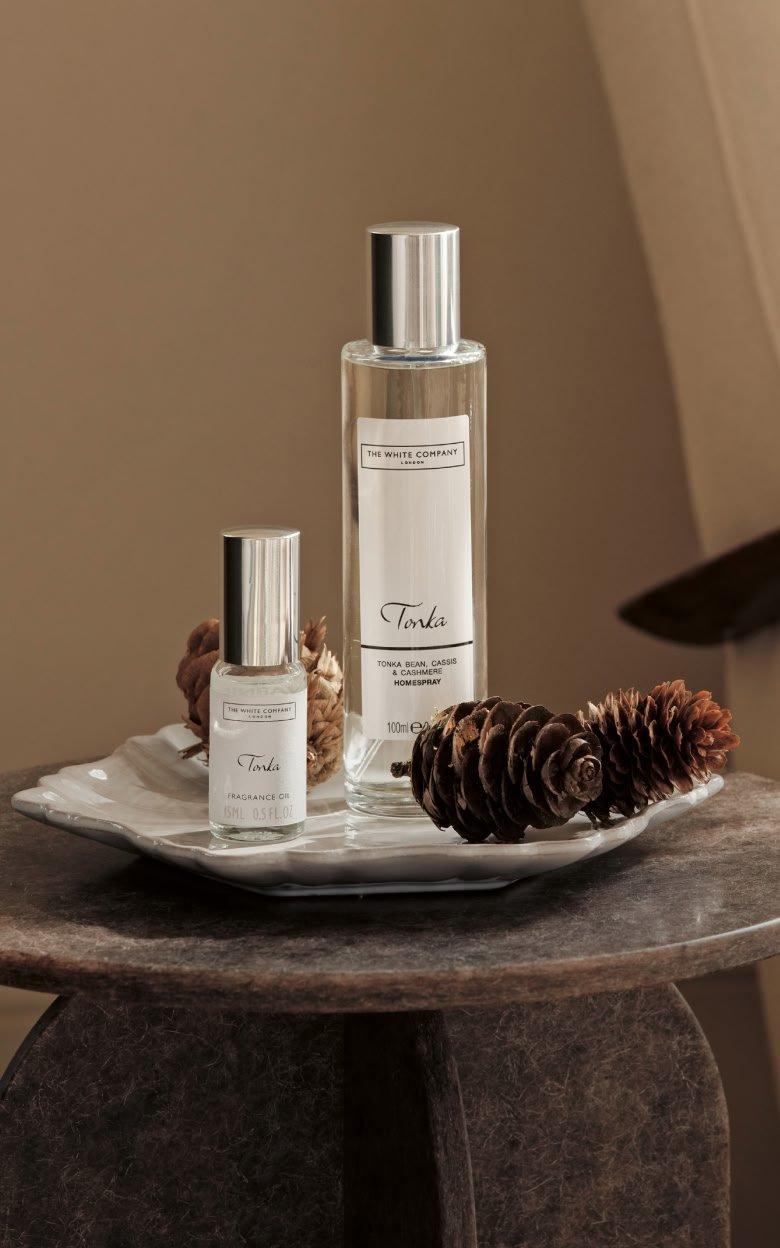 a table with two bottles of perfume and a pine cone