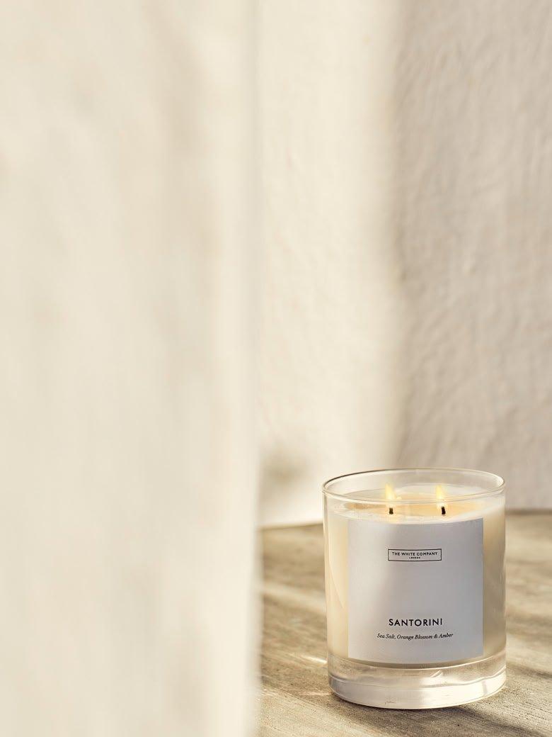 a small table with a candle and a vase of flowers