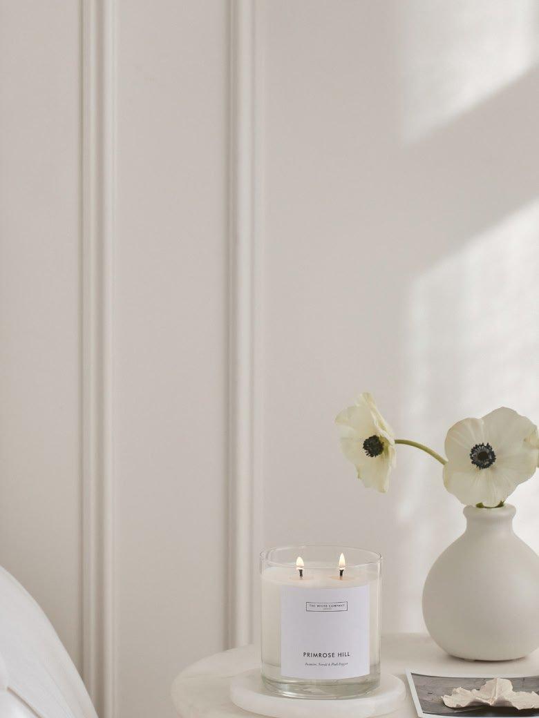 a small table with a candle and a vase of flowers