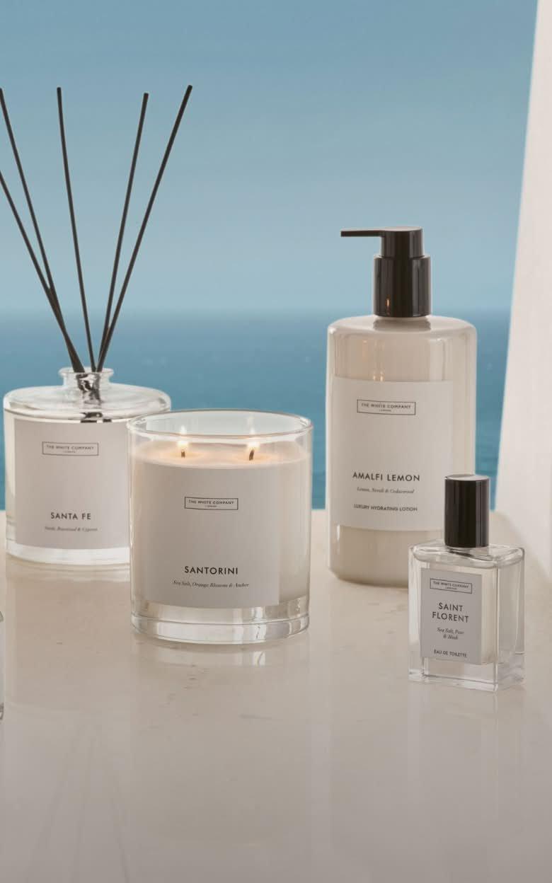 a group of candles and soaps are displayed on a table