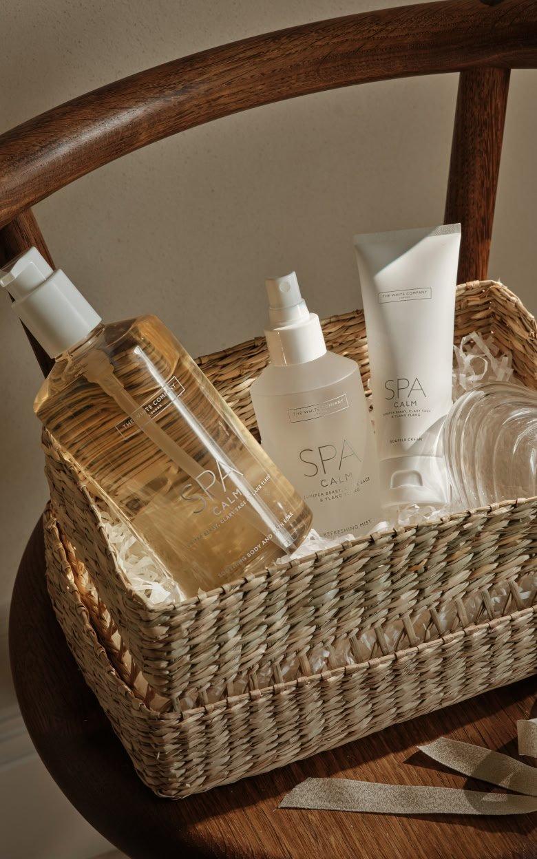 a basket with a bottle of lotion, a bottle of shampoo, and a bottle of body