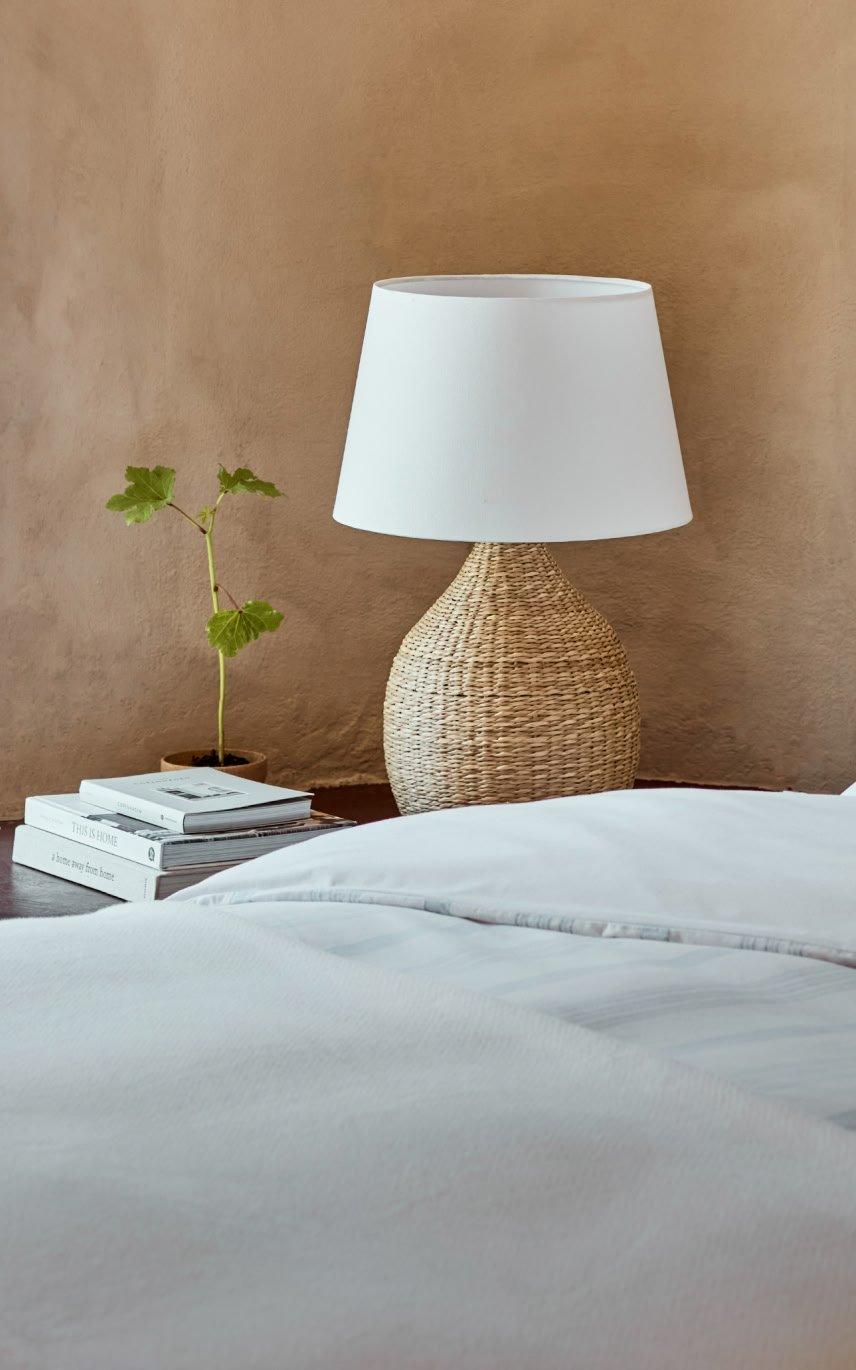 a bed with a white comforter and pillows on a white bed