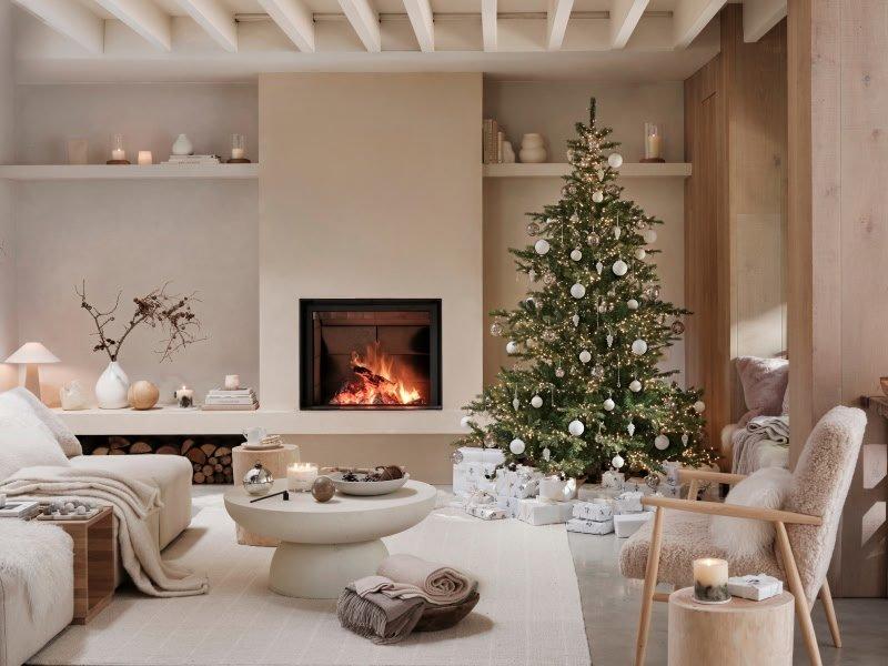 a living room with a fireplace and a christmas tree