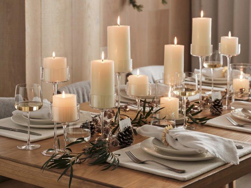 a table set with candles and plates and napkins