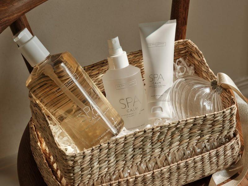 a basket with a bottle of lotion, a bottle of shampoo, and a bottle of body