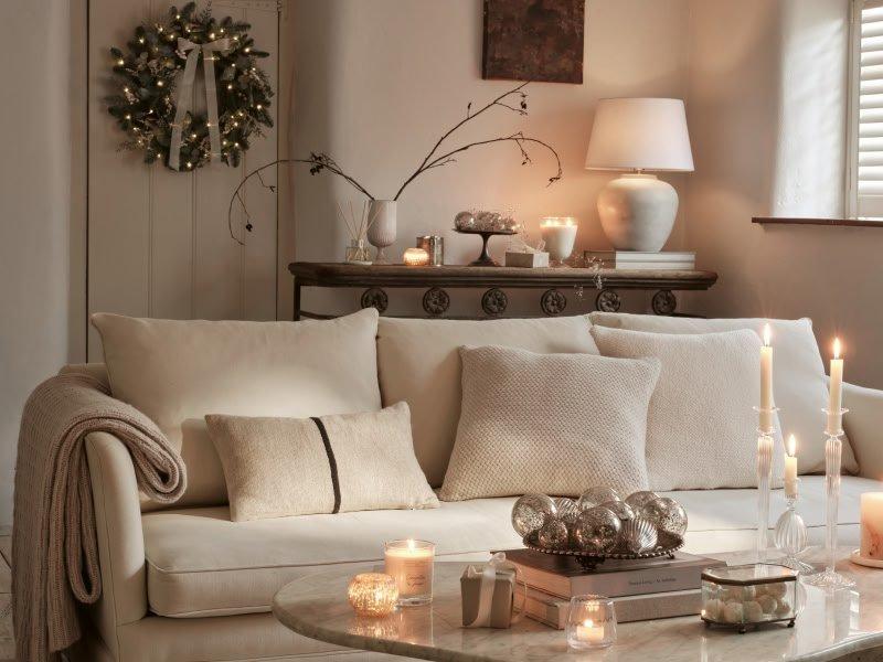 a living room with a white couch and candles on the table