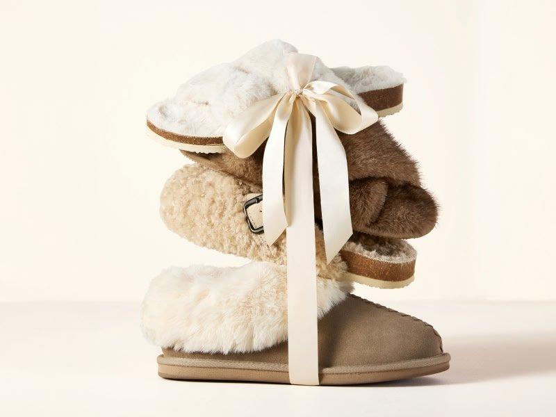 a stack of three pairs of ugg boots with a ribbon tied around them