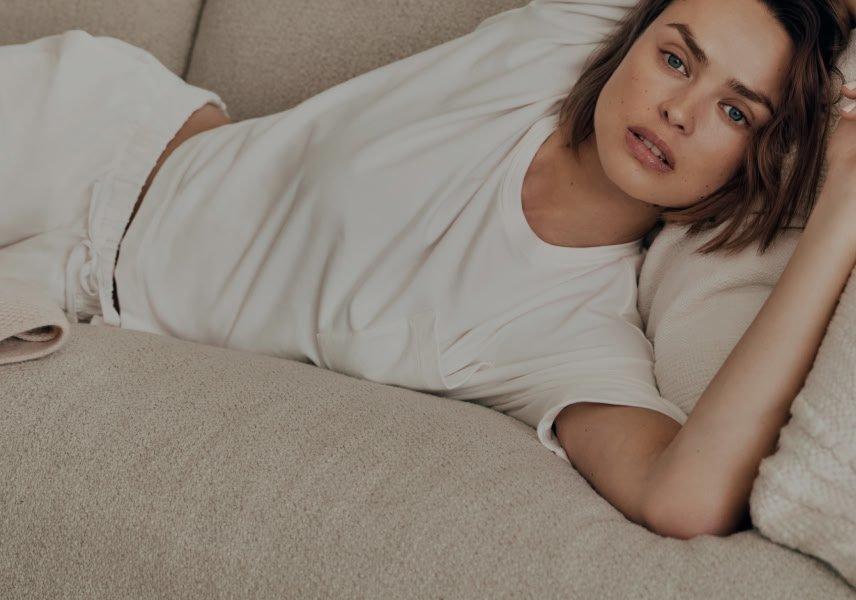 a woman laying on a couch with her hands on her stomach