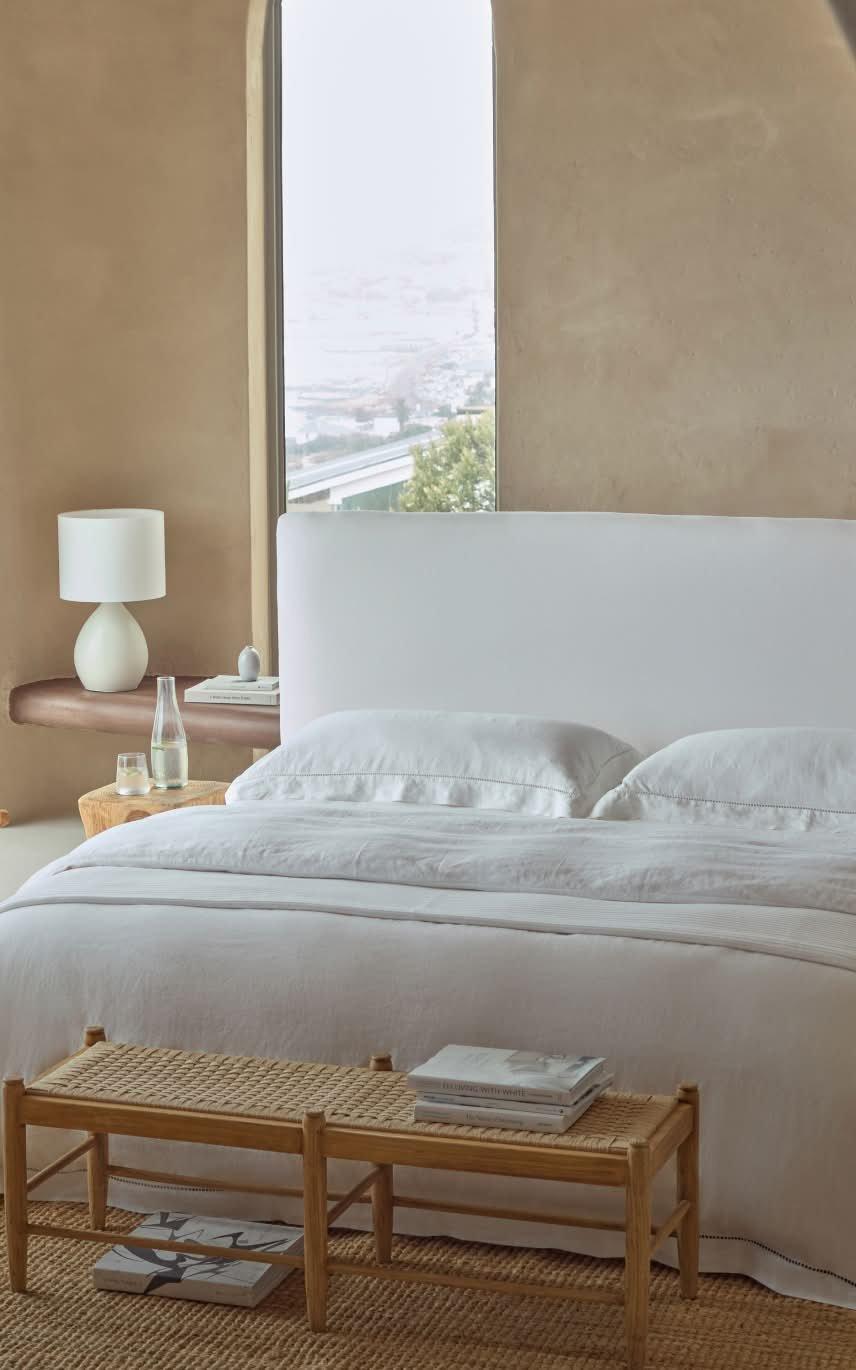 a bedroom with a white bed and a chair in it