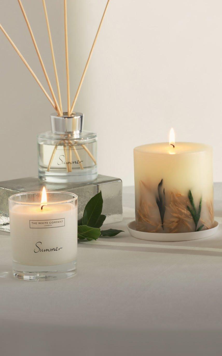 a table with candles and other items on it on a white table cloth