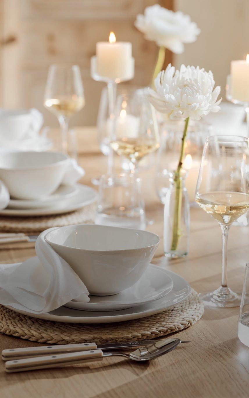 a table with a white plate and a white bowl with a white flower