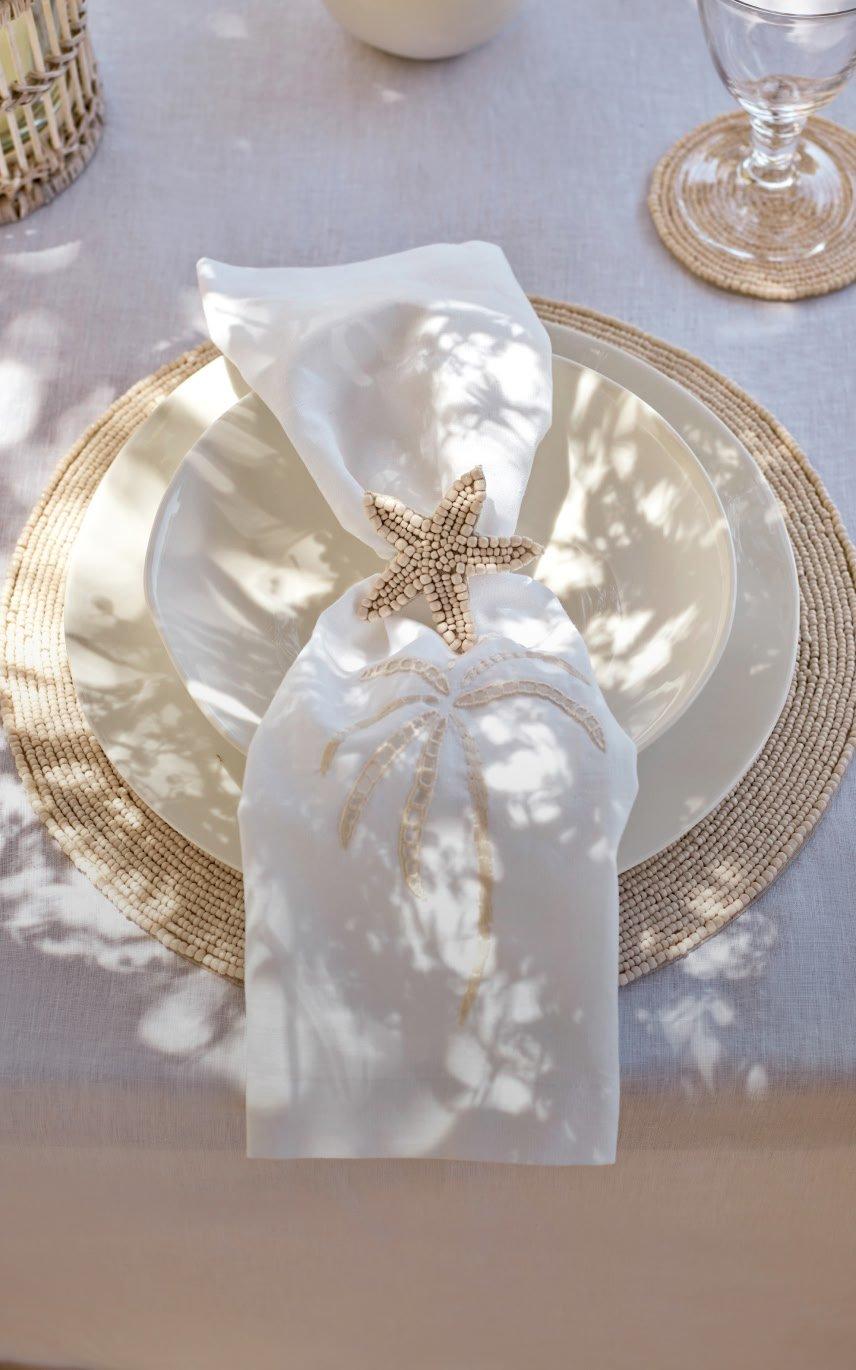 a white napkin with a starfish on it is placed on a table
