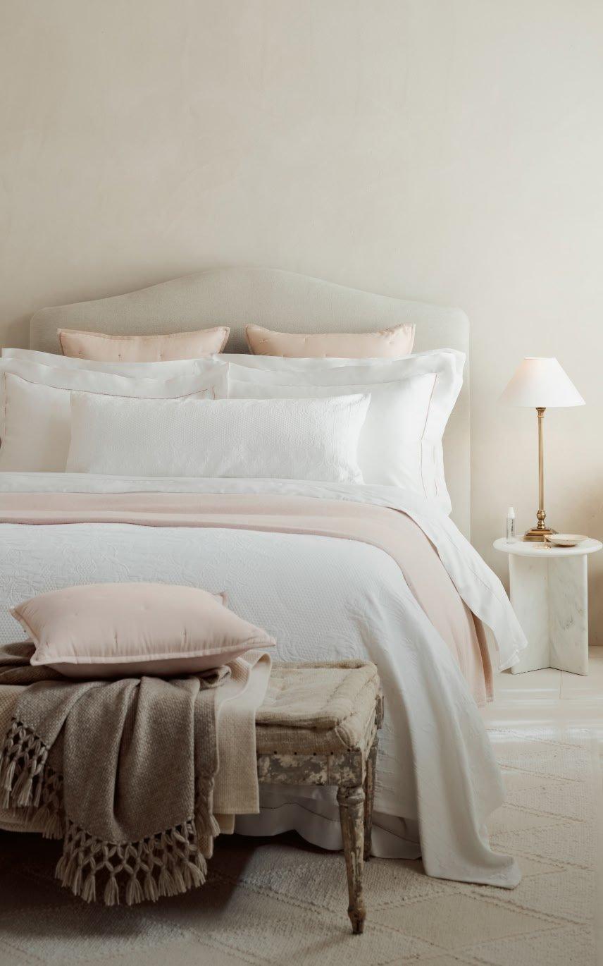a bed with a white comforter and pillows on it