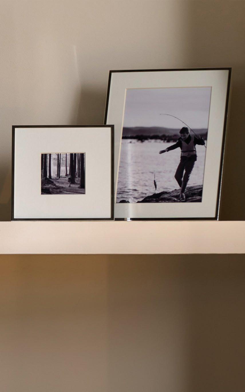a shelf with a vase, a picture and a vase of flowers