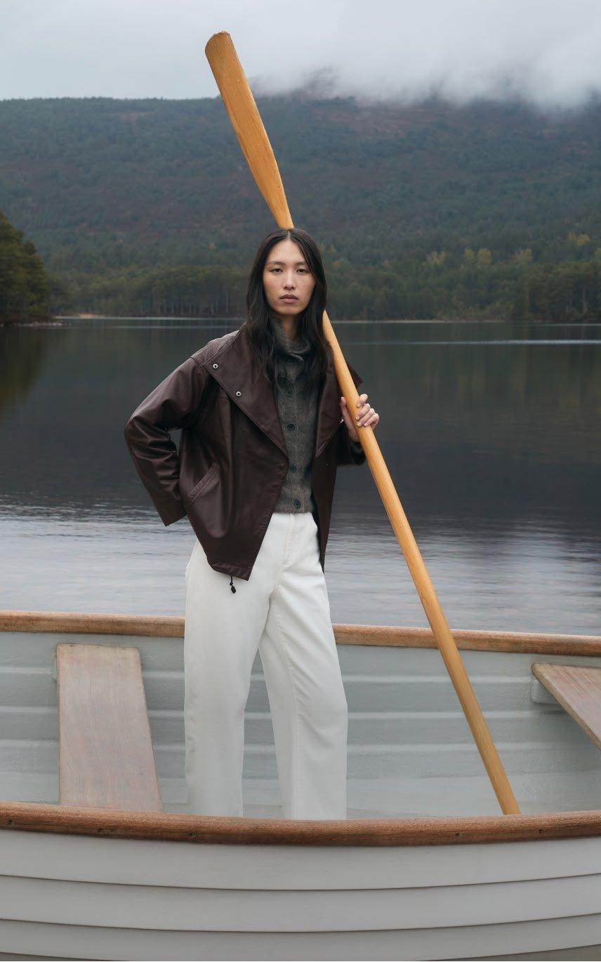 a woman standing on a lake with a paddle in her hand