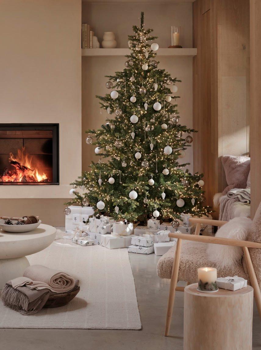 a living room with a fireplace and a christmas tree