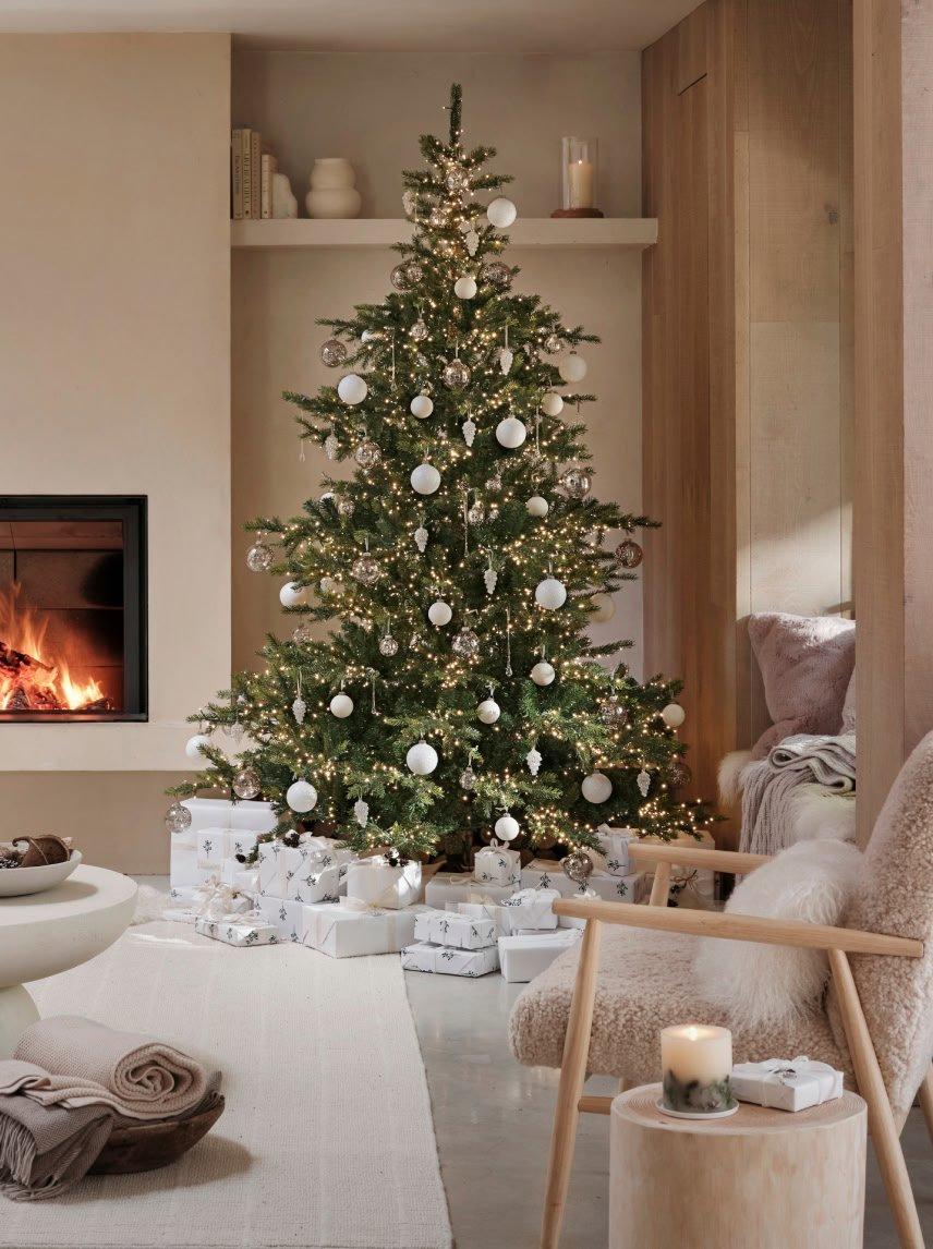 a living room with a fireplace and a christmas tree