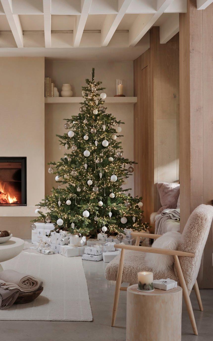a living room with a christmas tree and a fireplace