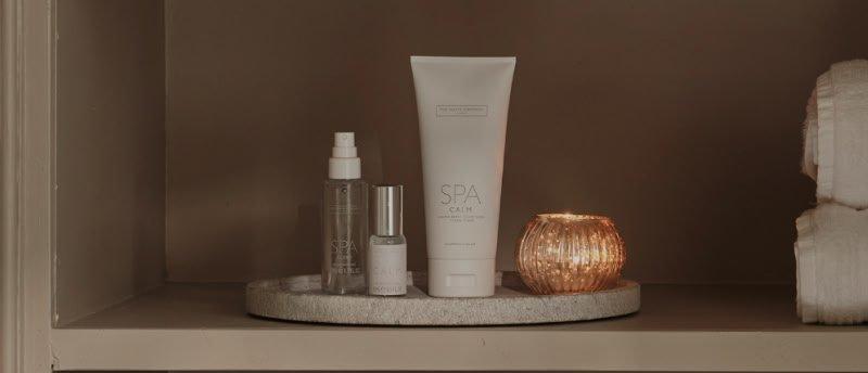 a tray with a candle and some skin care products on it
