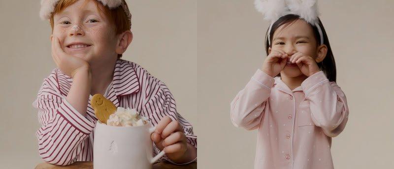 a young boy with a red hat and a cup of hot chocolate
