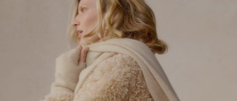 a woman in a fur coat holding a gift in her hand