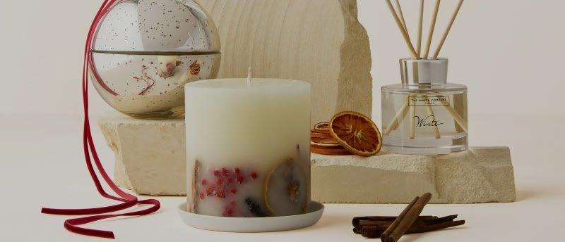 a candle, a candle holder, and a candle are displayed on a table
