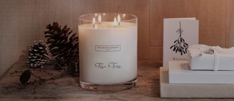 a candle, a box of white presents and a box of white candles