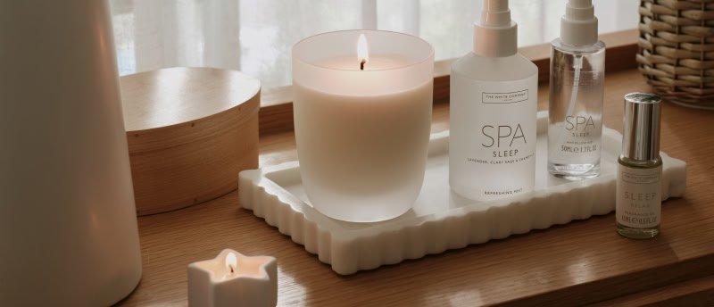 a tray with a candle, a bottle of water and a spray bottle