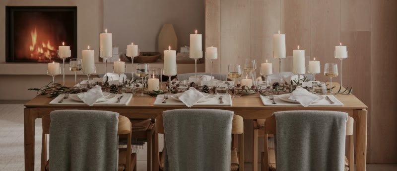 a dining table with candles and a blanket on it