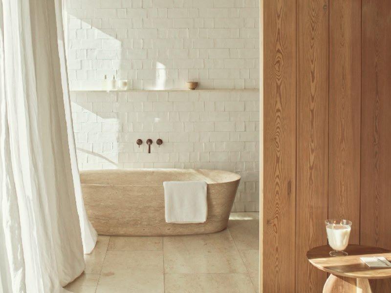 a bathroom with a tub and a window with curtains